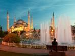 Man sitting on a bench opposite of blue mosque in Istanbul.