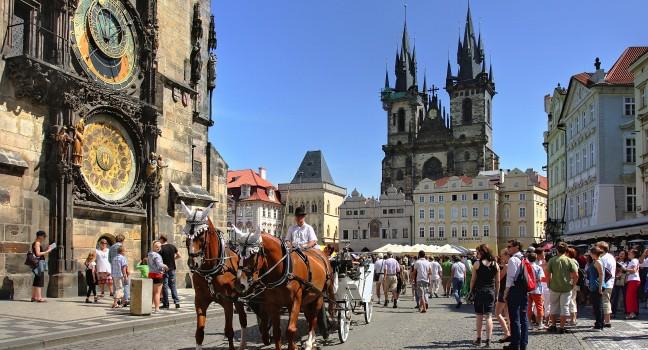 PRAGUE - JULY 17 : Tourist carriage passes by Old Town Square (Stare Mesto) in front of Tyn Church and famous Astronomical Clock july 17, 2009 in Prague, Czech Republic.