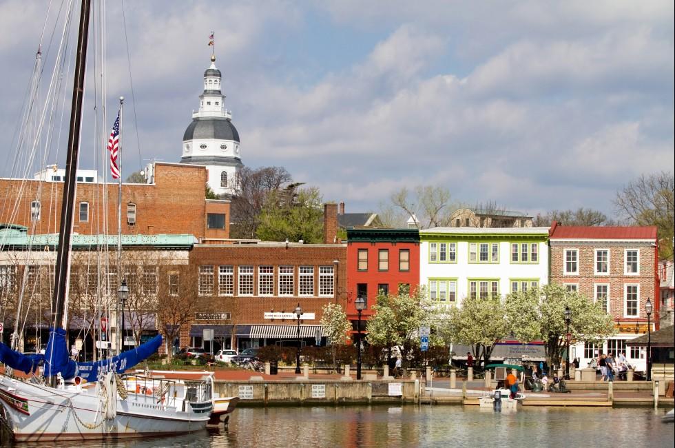 ANNAPOLIS, MARYLAND, USA - APRIL 12, 2013: Tourists shop along the waterfront in historic downtown Annapolis, Maryland, USA, the state capital, dome visible in the background, on April 12, 2013.