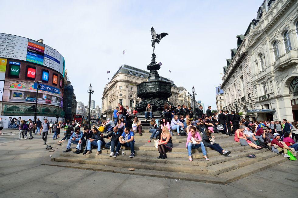 People enjoying the sun at Piccadilly Circus London.