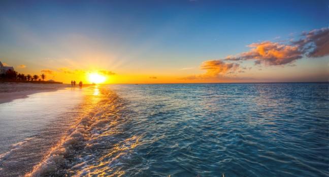 Grace Bay Beach, Turks &amp; Caicos, with the setting sun at the horizon.