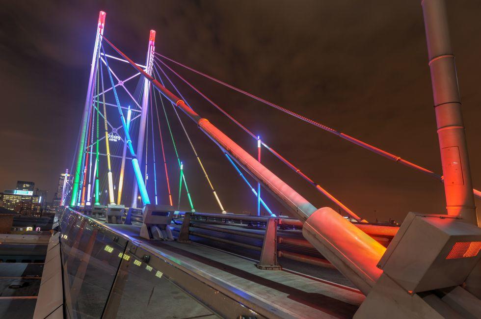 Nelson Mandela Bridge at night. The 284 meter long Nelson Mandela Bridge, officially opened by Nelson Mandela himself, which crosses over the 40 railway lines that lie spread beneath its span.